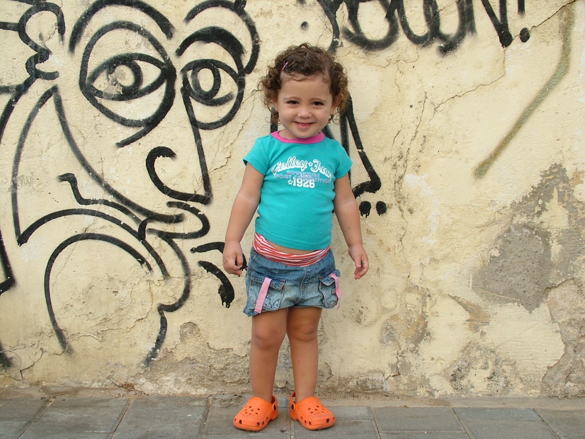 נועה פעוטה ליד קיר גרפיטי